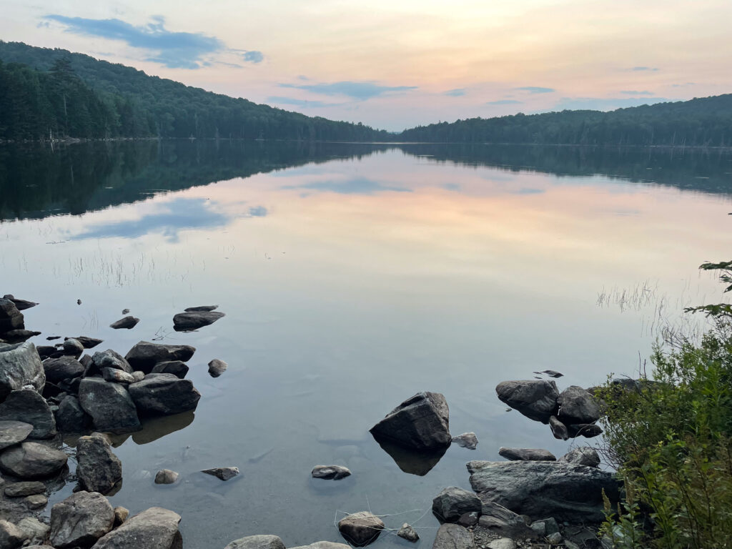 Sunset colors reflected in the calm water of Stratton Pond