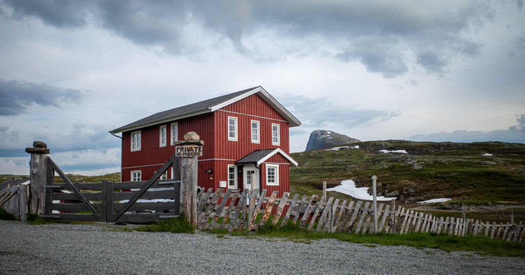 Red cabin near Bygdin Hotel with Bitihorn in the distance