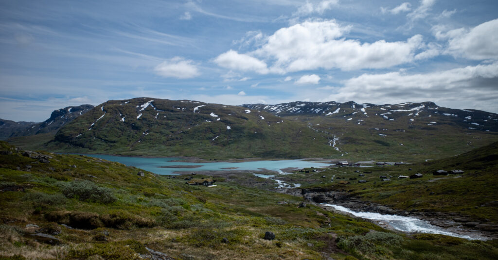Eidsbugarden and Fondsbu beside Lake Bygdin from the approaching trail