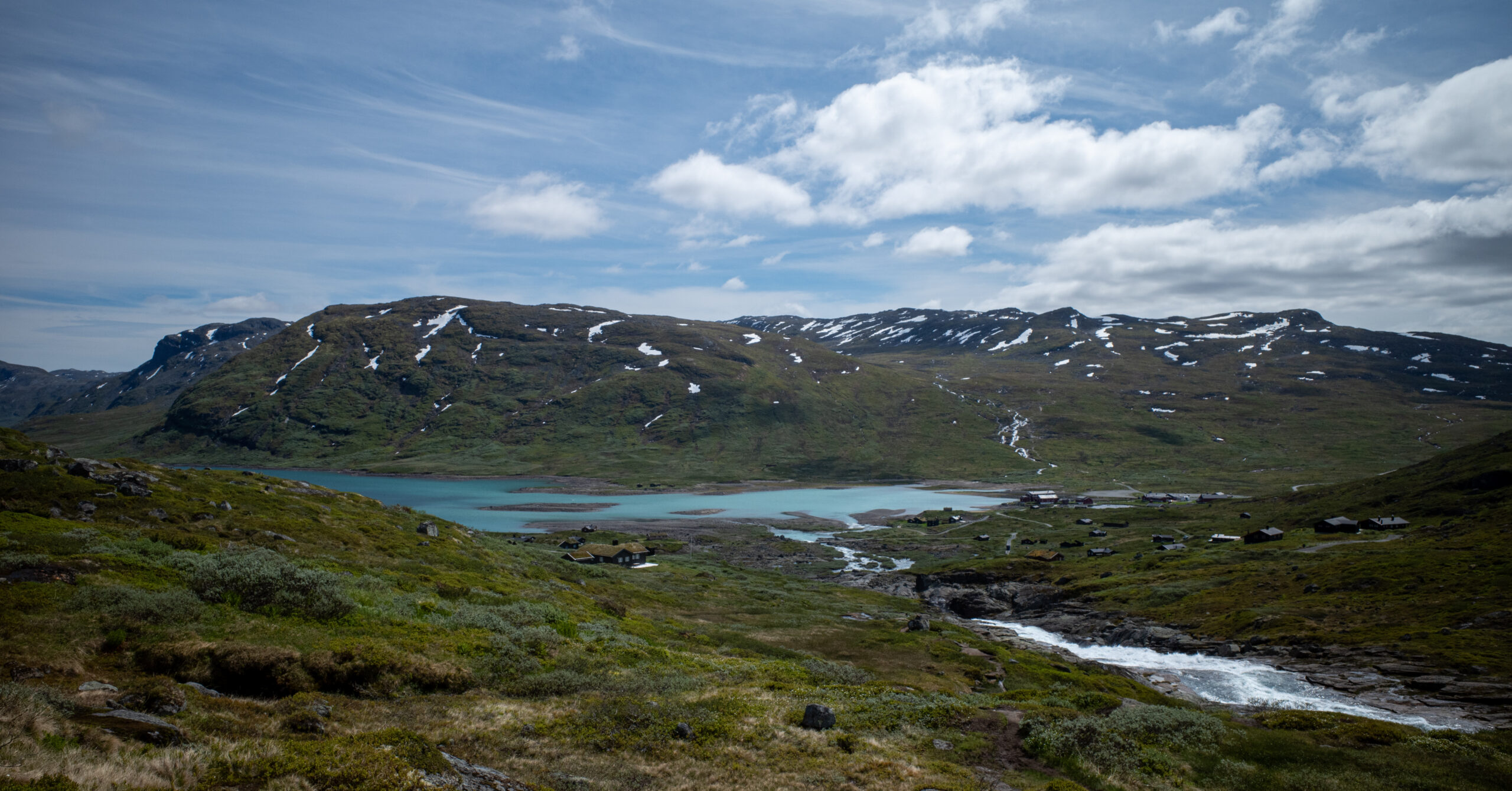 Eidsbugarden and Fondsbu beside Lake Bygdin from the approaching trail