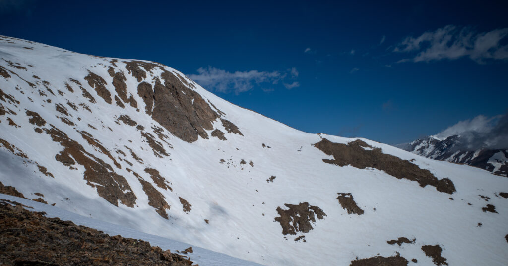 Snow-covered upper slopes and rocky outcrops beside Mount Elbert's East Ridge