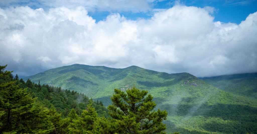 Layered Adirondack ridges beneath lifting clouds from a viewpoint near Rooster Comb