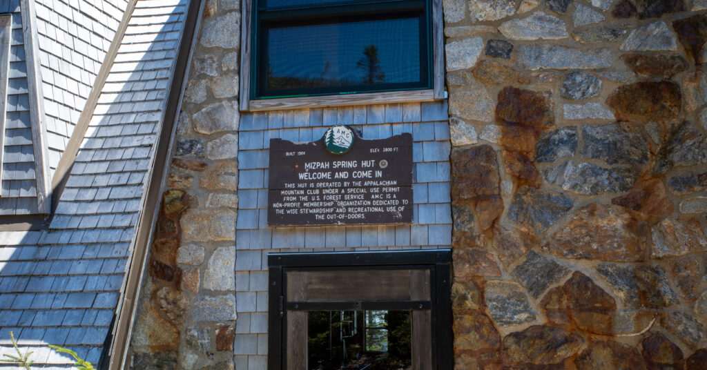 Stone entrance of Mizpah Spring Hut with its wooden welcome sign